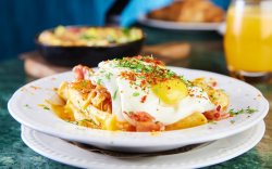 Sunny side up eggs with french fries , bacon, garlic & cheddar cheese image