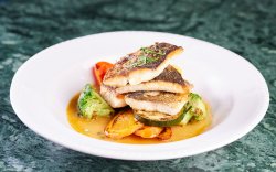 Oven cooked sea bass with small vegetables and capers image