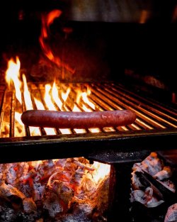 Cârnăciori afumati la cald,,care pocnesc" rumeniți la jar cu cartofi confiati în sos de usturoi artizanal cu ceapă verde și boia afumată. image