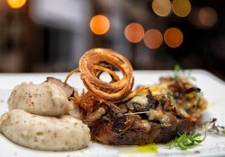 Ceafă de porc gătită lent cu ciuperci gratinate şi ceapă crocantă cu cartofi pe plită image