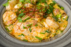 Creveți în sos de smântână pe pat de mămăligă aromată cu brânză ceddar/Shrimps in sour cream sauce on a bed of polenta flavoured with Cheddar cheese image