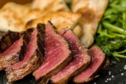 Tagliata din antricot de vită la grătar cu dresing chimichurri pe salată de rucola/Grilled beef Tagliata steak with Chimichurri dressing with rocket salad image