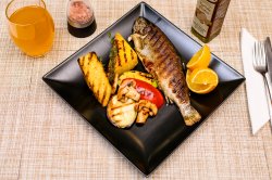 File de păstrăv la grill cu legume și mămăligă la grătar image