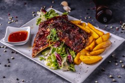 Coaste de porc cu cartofi wedges, salată mixtă și sos BBQ image