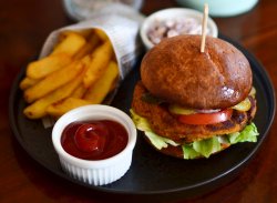 Burger vegan servit cu cartofi pai, ketkup si salata coleslaw vegana image